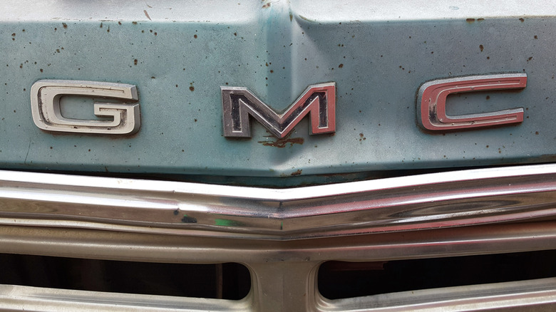 A GMC grill badge on an old automobile.