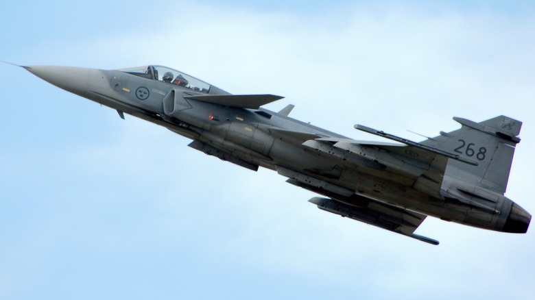 A Saab JAS-39 Gripen flying over cloudy skies