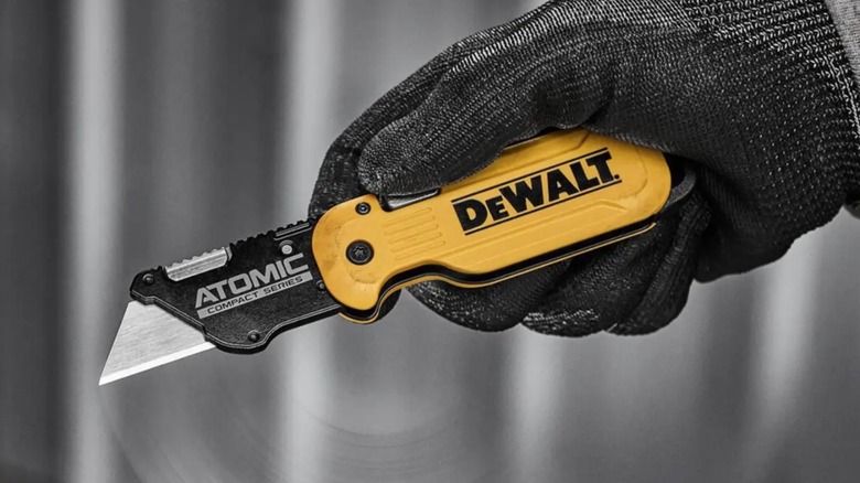 Person holding folding DeWalt utility knife