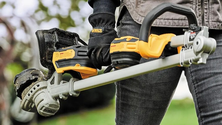 Person carrying folded DeWalt String Trimmer