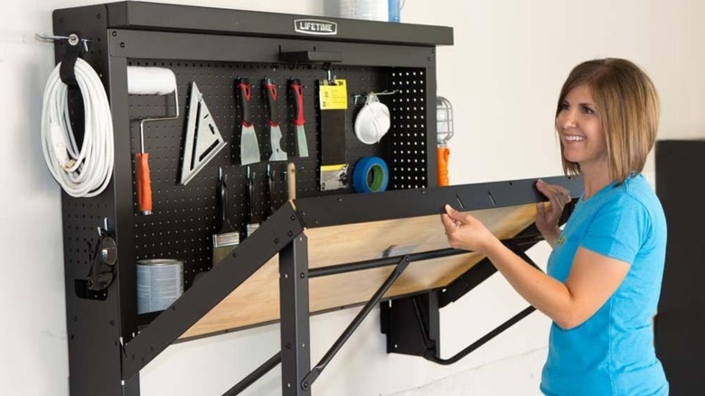 woman closing Lifetime Wall-Mounted Folding Work Table