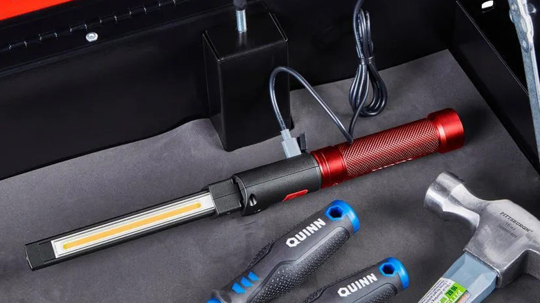 A red Icon foldable work light on a work bench.