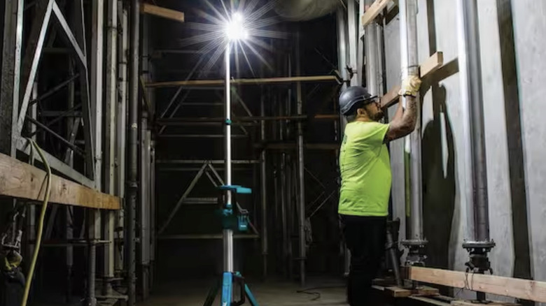 A workman with a Makita tower light on a job site