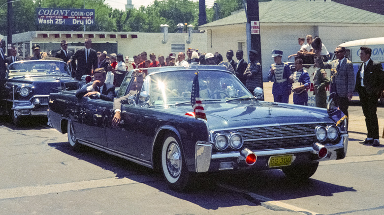 JFK riding down street in presidential limo