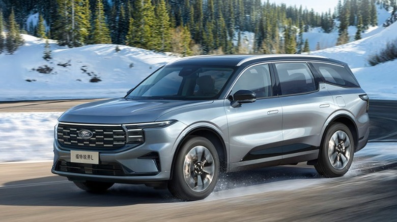 A gray Ford Edge L driving on a snowy road