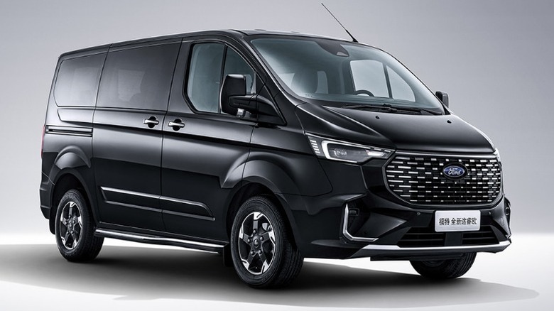 A black Ford Tourneo against a gray background, from a three-quarter view