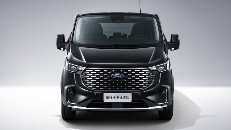 The front view of a black Ford Tourneo on a gray background