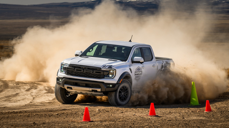 Front view of white Ford Ranger Raptor off-roading in desert.
