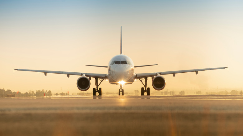 plane on runway at sunset