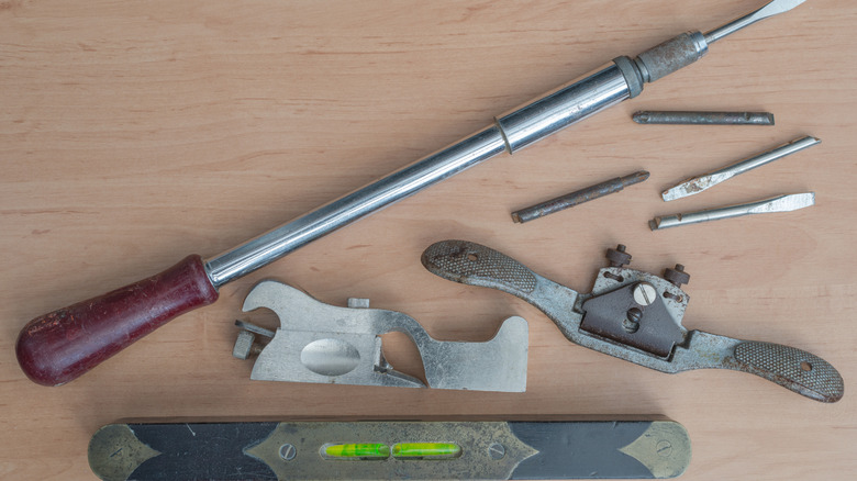 Vintage tools including Yankee screwdriver, tap-and-die set, and level