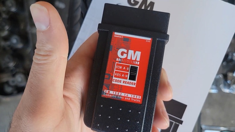 Person holding GM OBD-1 scanner tool