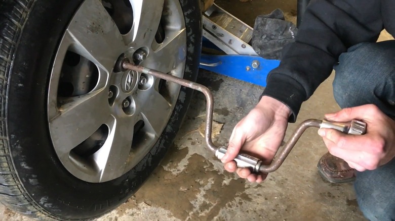 Mechanic servicing wheel with speeder wrench