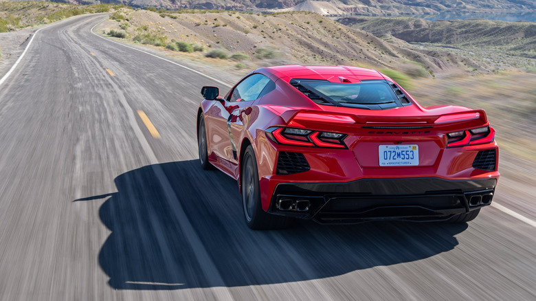 Rear view of red 2020 Corvette Stingray driving on desert highway.