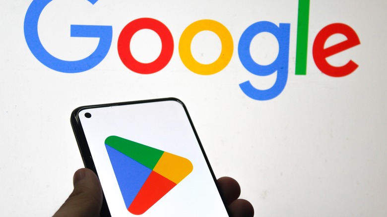 Google Play Store on Android phone in front of Google logo
