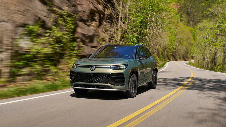 A frontal 3/4 picture of a green 2026 Volkswagen Tiguan driving
