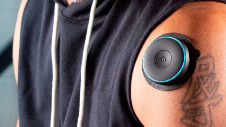 Person using muscle stimulator on shoulder