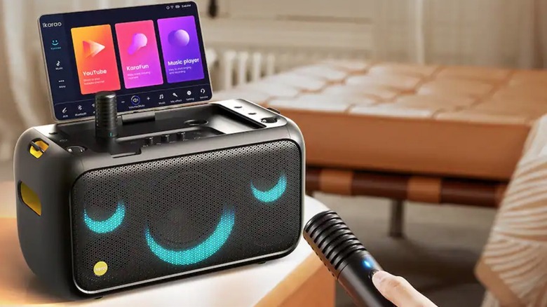 Person connecting microphone to Ikarao Karaoke Machine