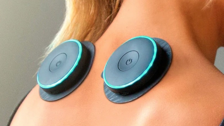 Person using muscle stimulator on upper back