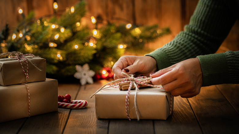 woman tying ribbon on present