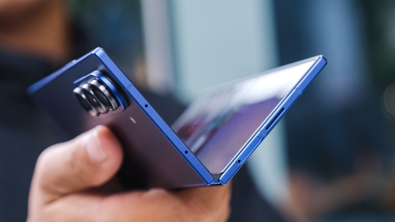 A hand holding out a blue Samsung Galaxy Z Fold7 that is partially folded