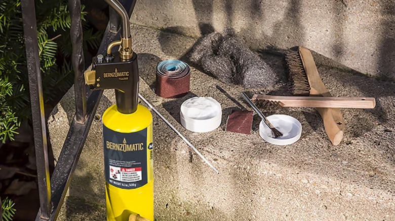 A Bernzomatic torch kit displayed on concrete outdoor steps