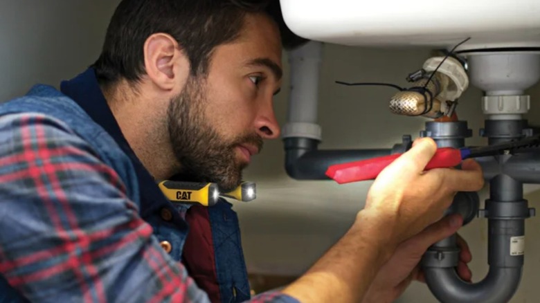 Person using Cat LED Neck Light while plumbing