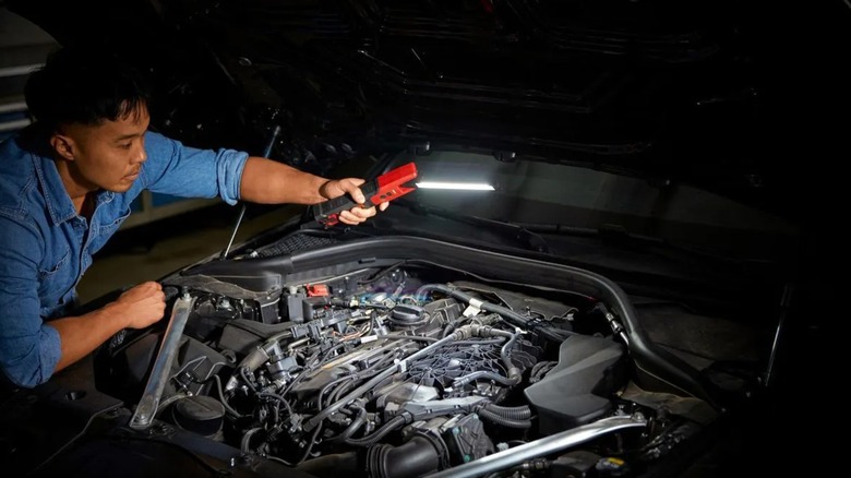 man using LED light on car