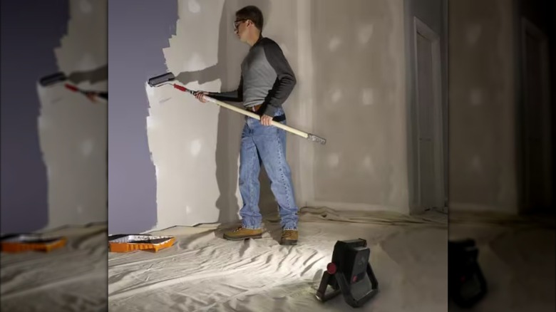 The Husky 2,000 lumen LED work light illuminating a dark room for painting.