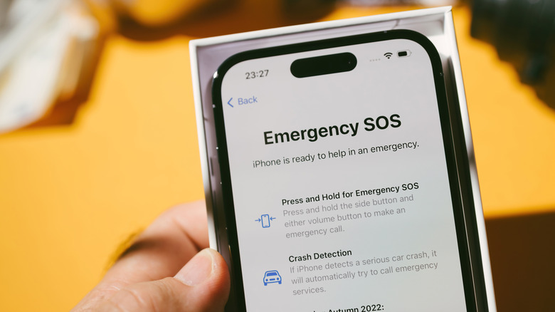 An iPhone sitting in its box displaying the Emergency SOS screen