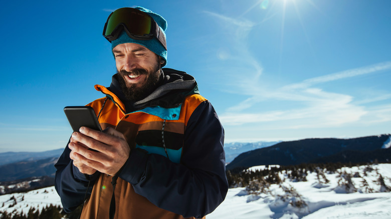A skier checking his phone