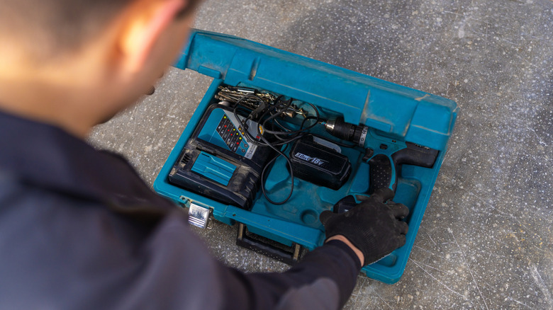 A person reaching into their toolbox
