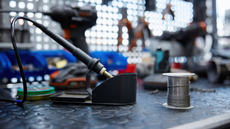 A soldering iron resting on its stand inside a garage