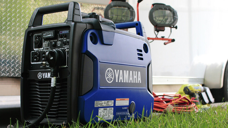 A Yamaha EF2200iS near an RV on the grass.