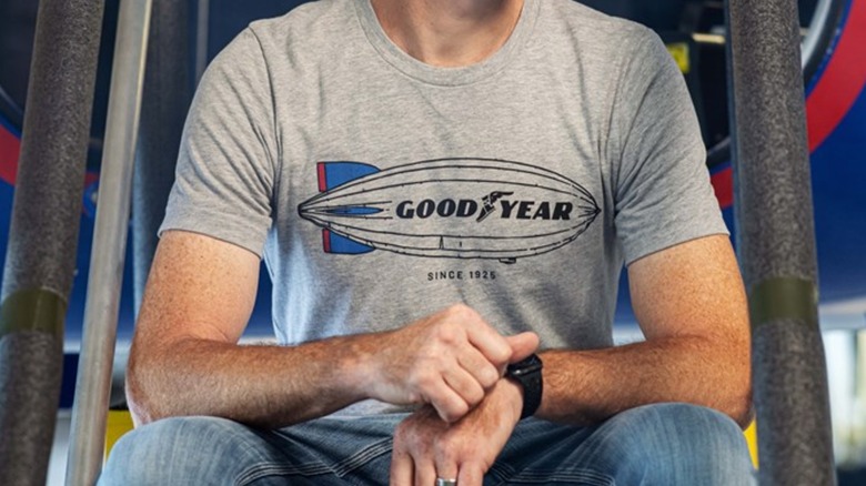A person wearing a gray Goodyear t-shirt.