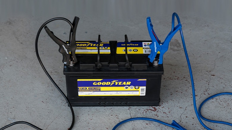 A Goodyear battery connected to jumper cables.