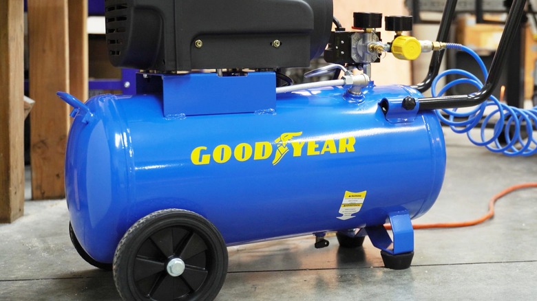 A Goodyear air compressor on a jobsite floor.