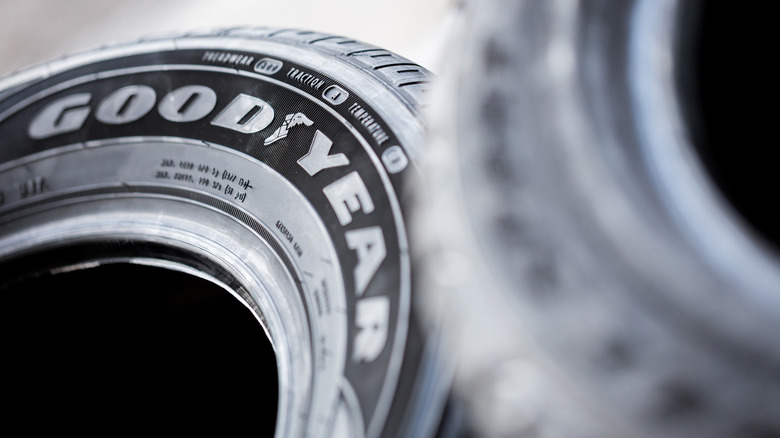 Close-up of the Goodyear logo on a Goodyear tire, with an out-of-focus tire in the foreground