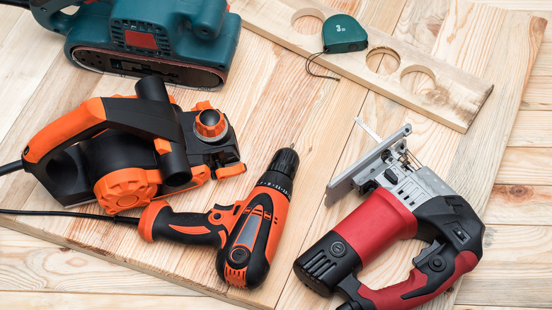 A set of power tool on top of a wooden platform.