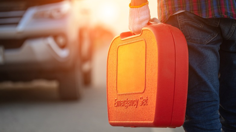 Man walking to car with toolbox