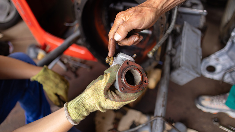 Grandfather pointing out a car part to grandchild