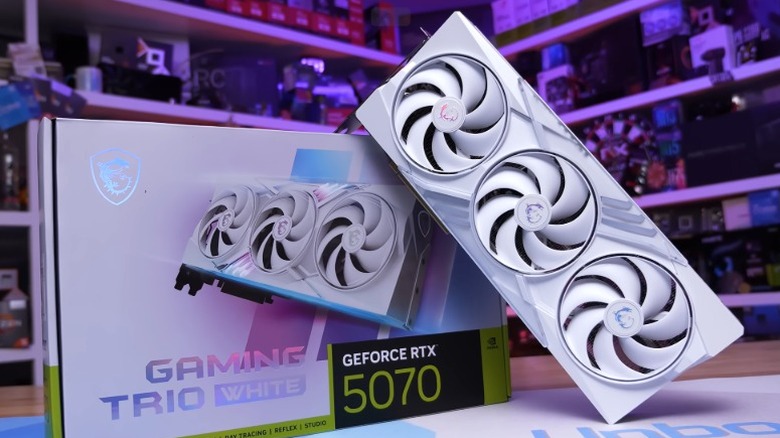 White MSI GeForce RTX 5070 graphics card on a table leaning against its box.