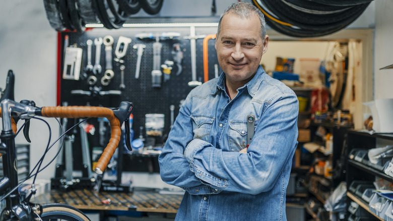 man in a workshop with bicycle and tools