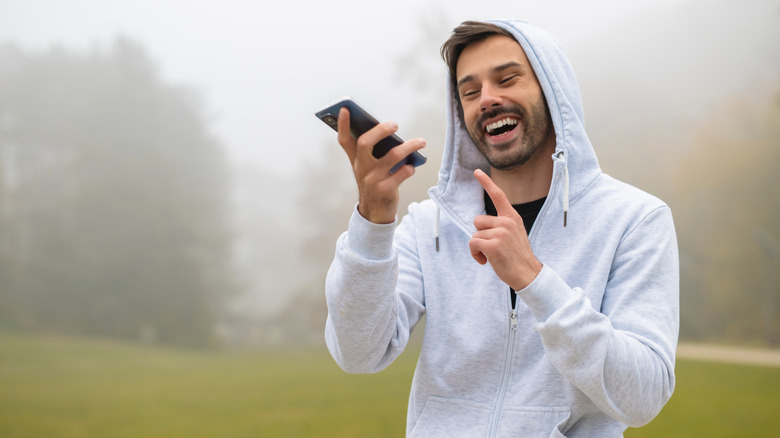 Man holding phone in hand to send voice message.