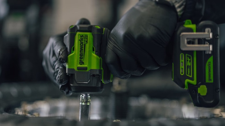 A person using a Greenworks Pro impact wrench.