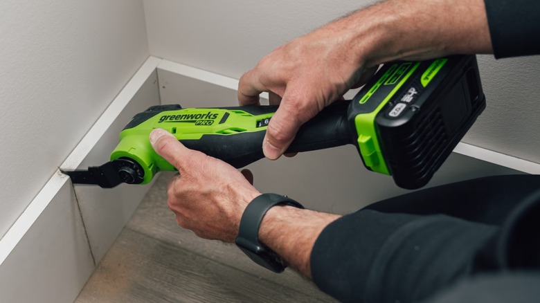 A person using a Greenworks Pro multi-tool.