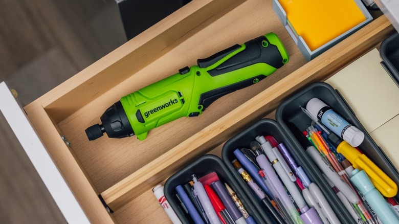 A Greenworks Power Screwdriver in a drawer.