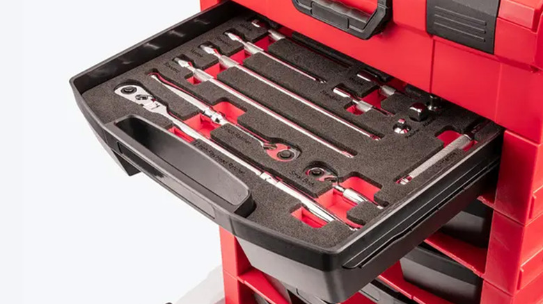 A toolbox with a drawer pulled out, full of tools.