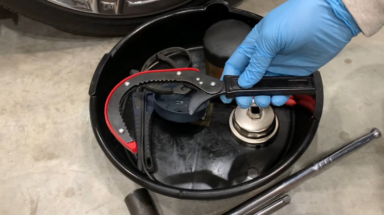 A close up of an oil filter wrench being held