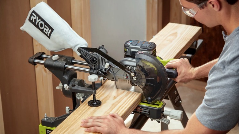 Person using a Ryobi compound miter saw
