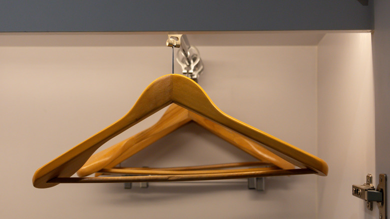 Theft-proof wood hangars hanging from a metal rack in a white closet